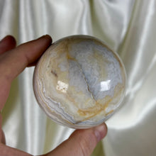 Load image into Gallery viewer, 12.8oz Banded Calcite & Agate “Creamsicle” Sphere (imperfect)